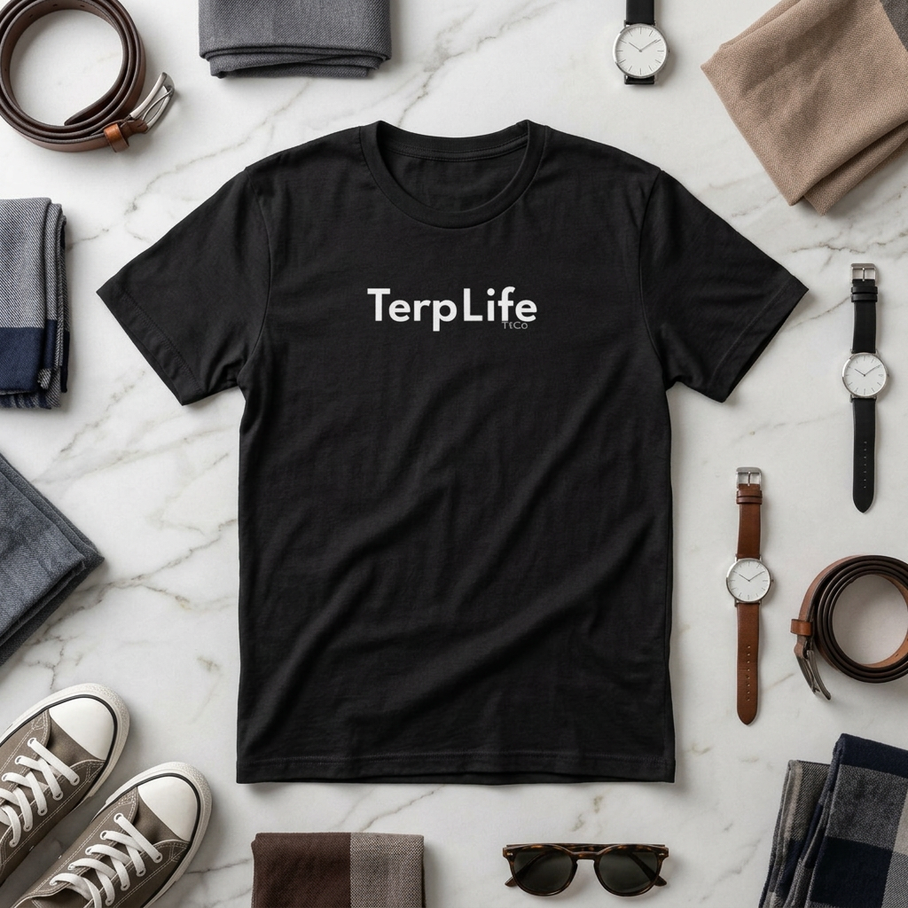 A black short-sleeve crewneck t-shirt with 'TerpLife' printed in white across the chest, styled in a flat lay on a white marble background surrounded by accessories. TtCo